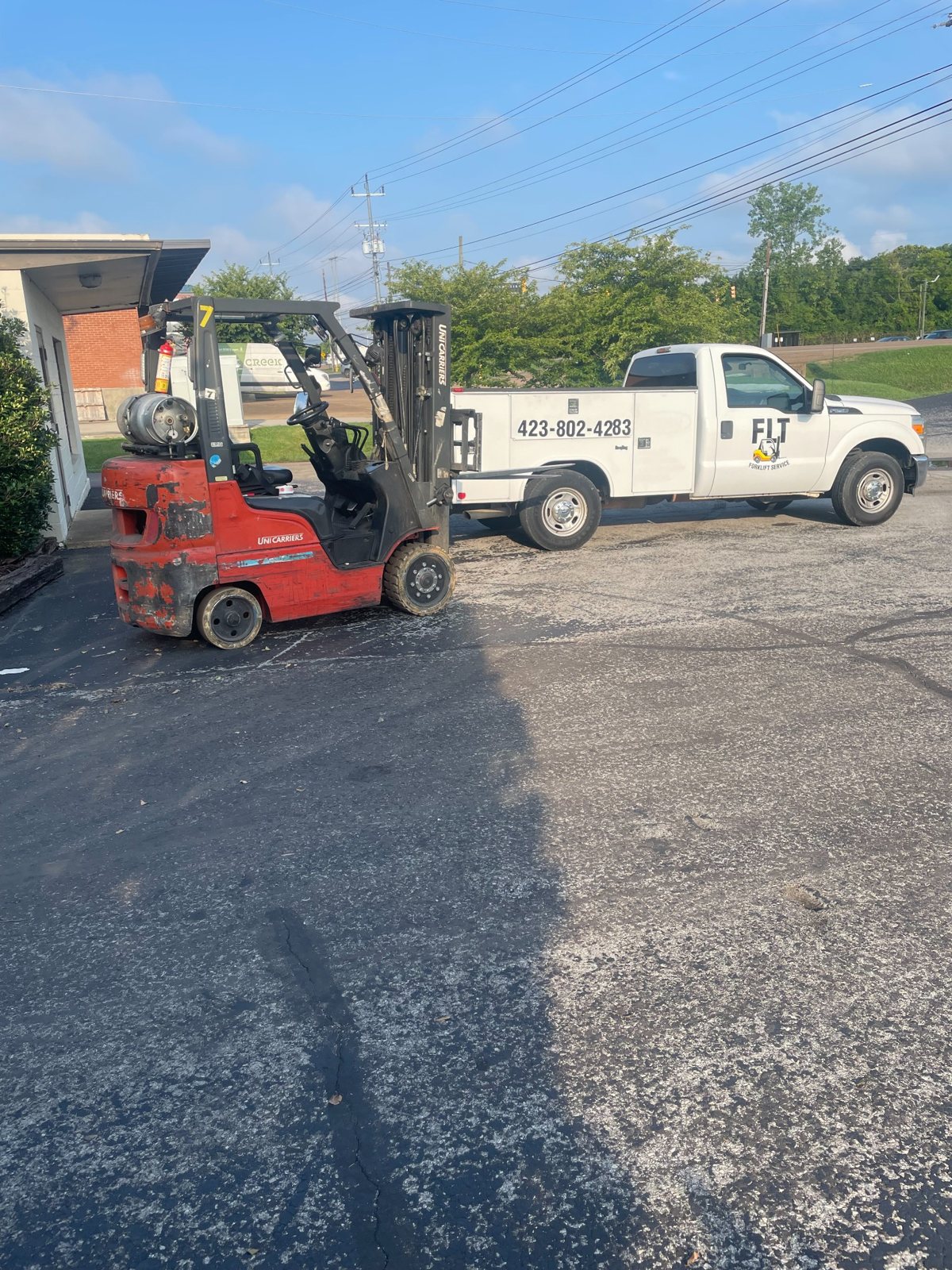 FLT Forklift Service truck beside a forklift